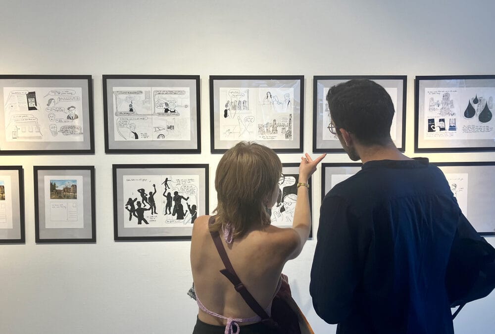 Ausstellungsbesucher:innen vor Arbeiten der Graphic-Novel-Serie “Gestern haben wir viel getanzt” der Zeichnerin Nathalie Frank, Berlin 2023.